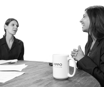 two women sitting at a table talking