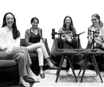 four women sitting and smiling with microphones